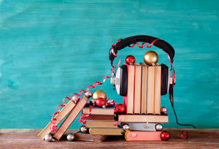audio books as christmas gift, present with christmas decoration, headphones and pieces of books, reading, literature, education, free copy spaceの写真素材