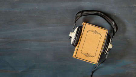audio book concept with book and vintage headphones,literature,entertainment,education,copy space on the book coverの写真素材