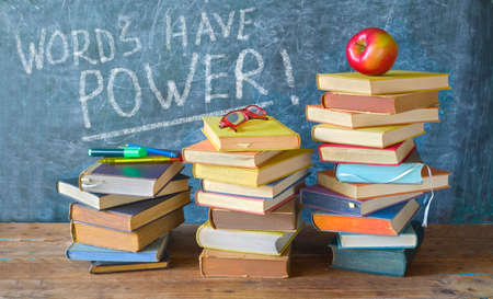 Stack of books and caption on black board Words have power, back to school,education...