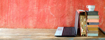 Stack of books, file folder and old laptop computer,home office, homeschooling,reading,education, business concept. Free copy space, panoramicの写真素材