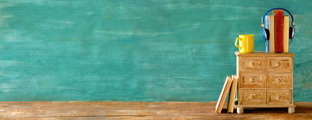 audio book concept, vintage books and headphones teal background, listening,literature,entertainment,education, panoramic good copy spaceの写真素材