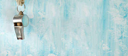 whistle of a soccer or football referee or trainer on blue grunge background, panoramic, free copy...