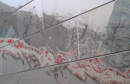 distorted refelction of a hoarding or building site fence and cityscape forming swirly abstract...