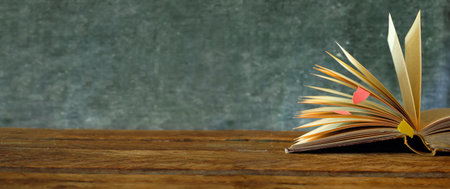 Open book, hardback book on dark blurred background. Back to school,education,reading.Panoramic...