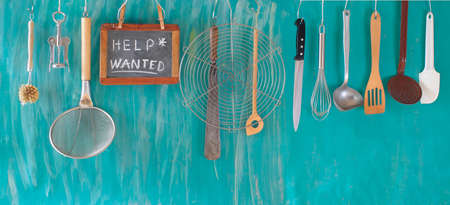 Help wanted sign,restaurant or cafe looking for staff after corona lockdown, kitchen utensils and job ad on blackboardの写真素材