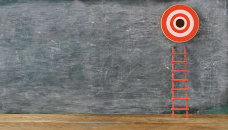 Stand out from the crowd and think different. Creative idea concepts with red ladder and ambitious target with copy space on blackboardの写真素材