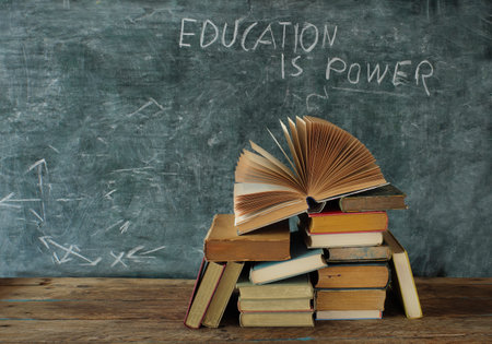 Open book, hardback books with education is power slogan on blackboard,education,learning and reading concept. Free copy spaceの写真素材