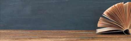 Open Book on dark background education,reading,knowledge concept.Panoramic, large copy space.
