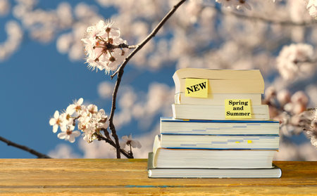 New book releases for spring 2023, with stack of books and cherry blossoms background.Spring Book fair, inspiration,reading, education, literature concept, free copy spaceの写真素材