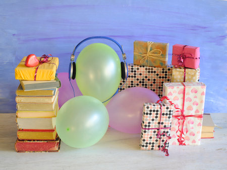 <p>audio book as birthday gift with books,vintage headphones,balloons and decoration,free copy space</p>の写真素材
