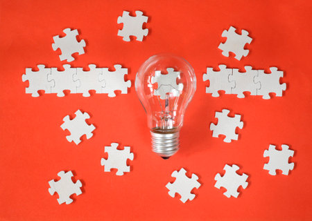Business concept,recruitment,human resources,innovation, team building.Light bulb and jigsaw puzzle with one piece missing. Free copy space.の写真素材