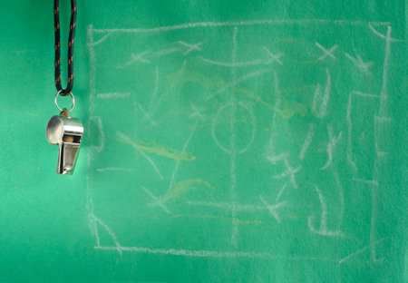 Whistle of soccer referee or trainer. Close up with soccer matach tactics scribble on green...