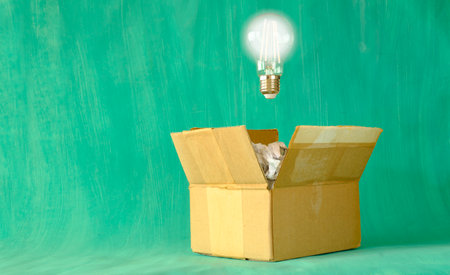 thinking outside the box, innovation, idea, vision, business concept, grungy box with crumpled paper and light bulb, symbolic and meataphoricの写真素材