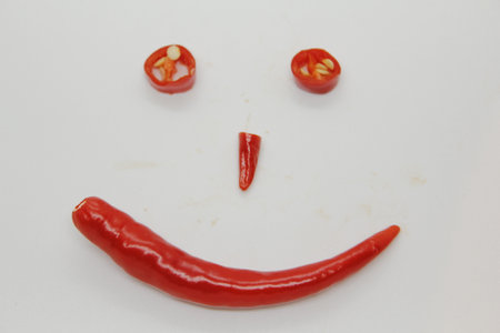 red hot chili pepper smiley face on white background, closeup of photoの写真素材