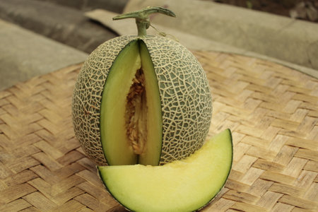 Melon on a bamboo tray on a background of brown soil.の写真素材