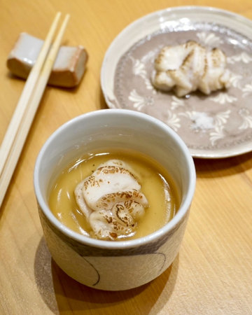 Mochi in a ceramic cup and chopsticks on a wooden tableの写真素材