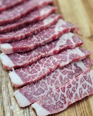 Raw sliced beef on a wooden board, selective focus, shallow DOF.の写真素材
