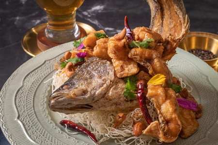 Fried fish with rice noodle and glass of beer on dark backgroundの写真素材