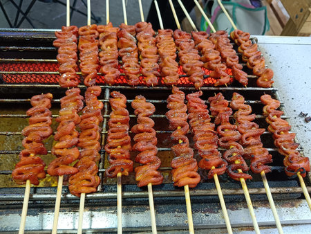 Sausage on the grill at the street food market in Thailandの写真素材