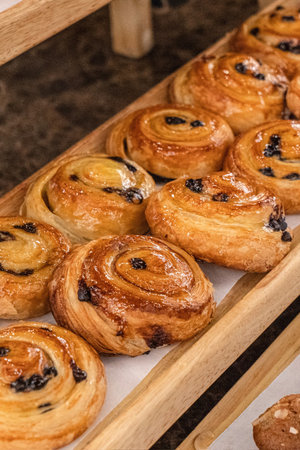 Freshly baked buns with raisins in a bakery.の写真素材