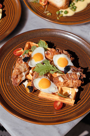 Belgian waffles with fried eggs and vegetables, close-upの写真素材
