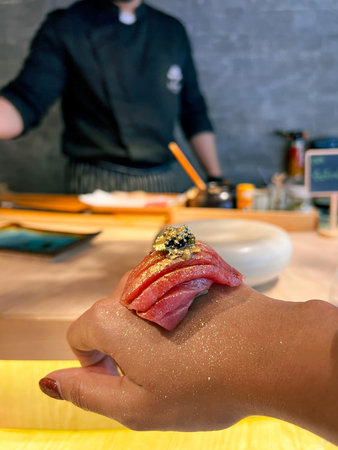 Close up of a chef's hand making sushi at the restaurant.の写真素材