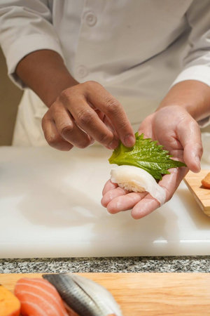 Chef preparing sushi in the kitchen, Close up of chef handsの写真素材