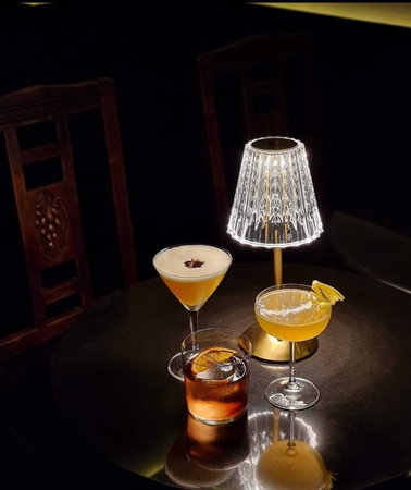 Cocktails on the table with a lamp. Black background.