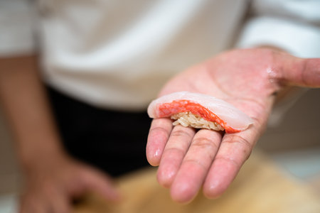 Chef preparing sushi in restaurant kitchen, closeup of hands.の写真素材