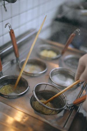 Cooking Japanese noodle in a restaurant kitchen, selective focus.の写真素材