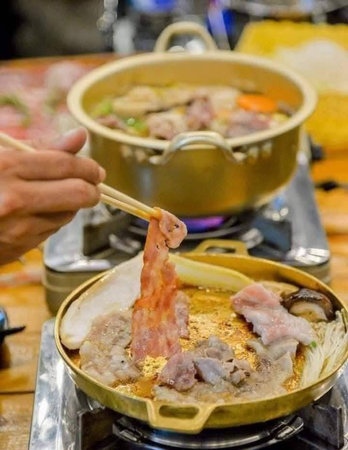 chopsticks picking up pork in hot pot, chinese cuisineの写真素材