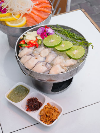 Raw fresh fish in a pot with vegetables and spices on the table