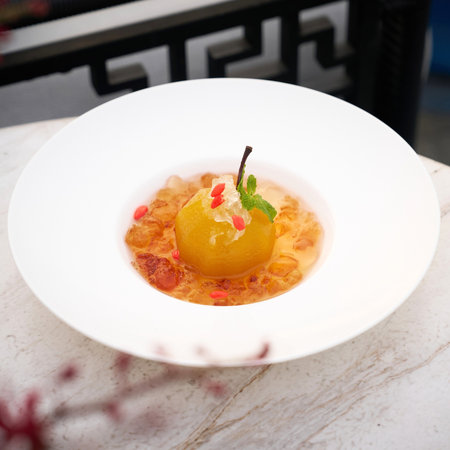 Fruit dessert with caramelized pears in white platele tableの写真素材