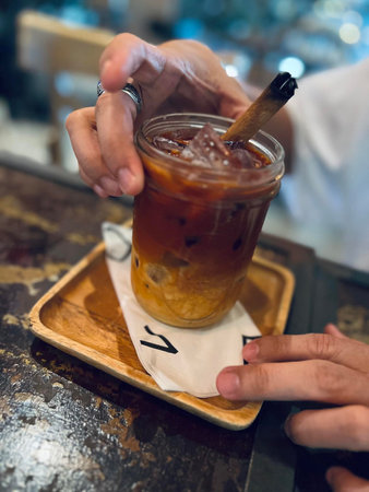 Iced coffee in a glass on a wooden tray, stock photo