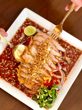 Thai style spicy salad with pork on wooden background, Thai foodの写真素材