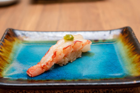 Japanese cuisine - Shrimp nigiri sushi with green peas on blue plateの写真素材