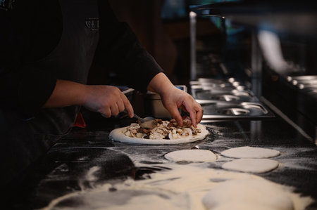 Close-up of chef preparing pizza at counter in restaurant. Food industryの写真素材