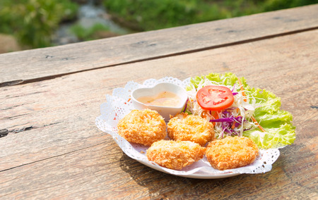 chicken nuggets served in a white bowl on wooden tableの写真素材