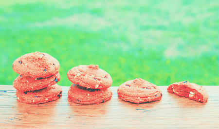 Stacked chocolate chip cookies on brown blackground.の写真素材