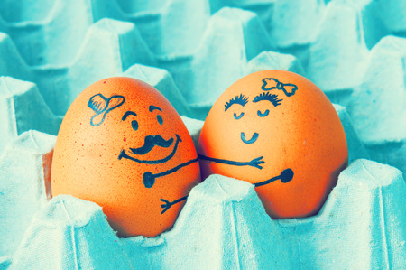 Two eggs hugging  arranged in carton