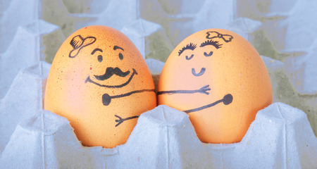 Two  eggs hugging couple arranged in cartonの写真素材