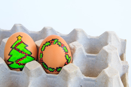 Christmas egg with faces drawn arranged in carton