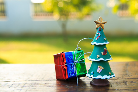 gift with Christmas Tree  on wood table ,in garden backgroundの写真素材