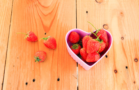 Red Strawberry in pink heart shape bowl on Valentine dayの写真素材