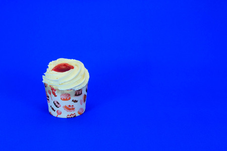 Cupcakes with buttercream frosting and strawberry jam on blue backgroundの写真素材