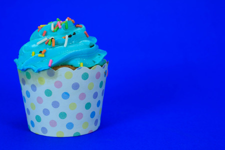 Blue Cupcake with colorful candy on blue backgroundの写真素材