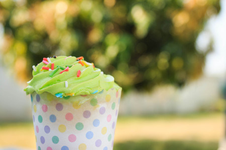 Green Cupcake with colorful candy in garden backgroundの写真素材