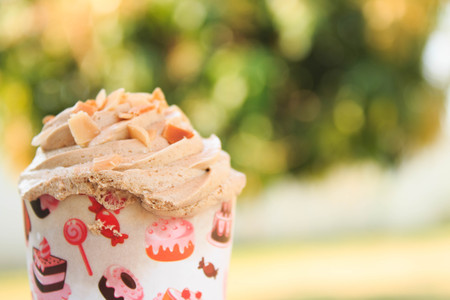 Coffee Cupcake with creamy with Almonds in garden backgroundの写真素材