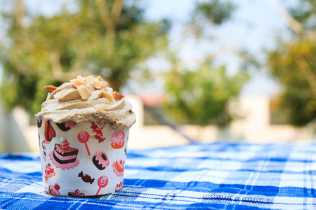 Coffee Cupcake with creamy with Almonds on blue picnic tablecloth in garden.の写真素材