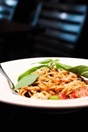 Stir-Fried Spaghetti With Dried Chili And sausage White plate on wood table.の写真素材